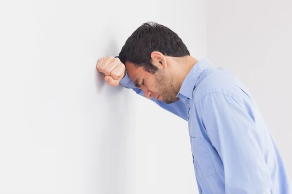 Aufgebrachter Mann lehnt seinen Kopf an eine Wand — Stockfoto