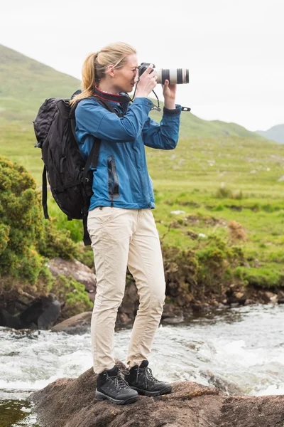 Blond kvinna på en vandring som tar ett foto — Stockfoto