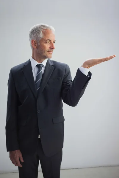 Hombre de negocios no sonriente presentando algo — Foto de Stock