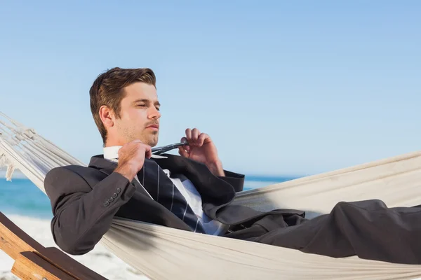 Businessman man lying in hamock taking off his tie — Stock Photo, Image