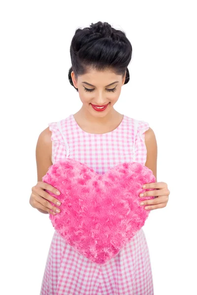 Pleased black hair model holding a pink heart shaped pillow — Stock Photo, Image