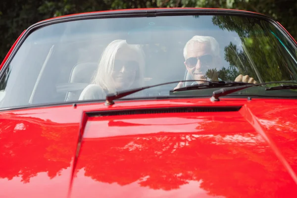 Smiling mature couple in red cabriolet — Stock Photo, Image