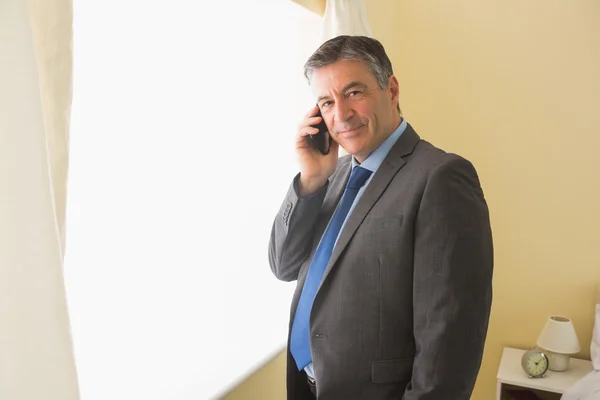 Homem satisfeito chamando alguém com seu telefone celular — Fotografia de Stock