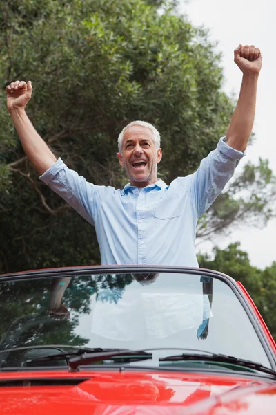 Smiling mature man enjoying his red convertible — Stock Photo, Image