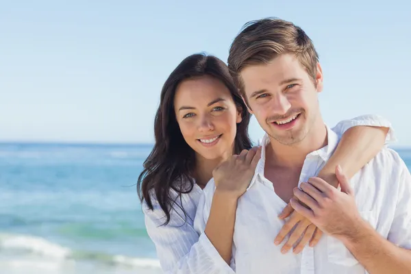 Fröhliches Paar, das sich am Strand umarmt — Stockfoto