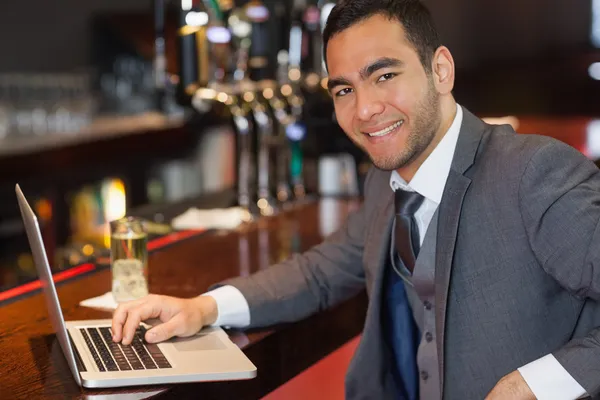 Lächelnder Geschäftsmann arbeitet an seinem Laptop — Stockfoto