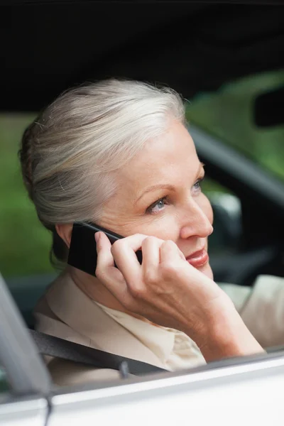 Vreedzame zakenvrouw op de telefoon besturen van stijlvolle auto — Stockfoto