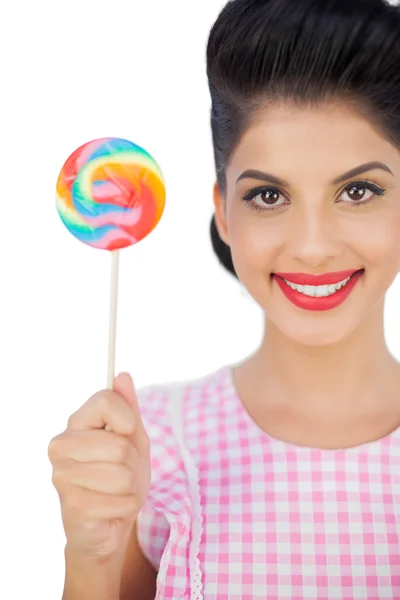 Pleased black hair model holding a colored lollipop — Stock Photo, Image