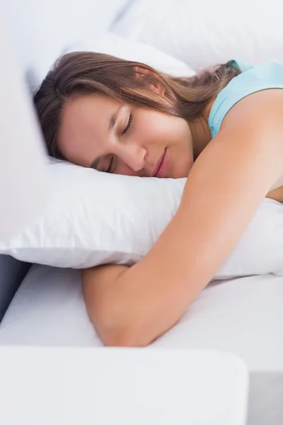 Atraktivní brunetka klidně spí v posteli — Stock fotografie