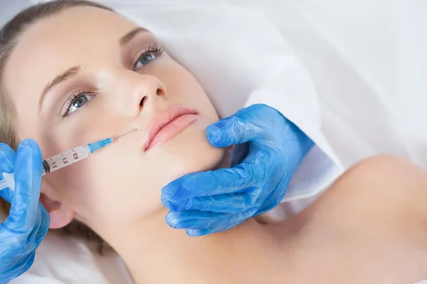 Surgeon making injection above lips on young woman lying — Stock Photo, Image