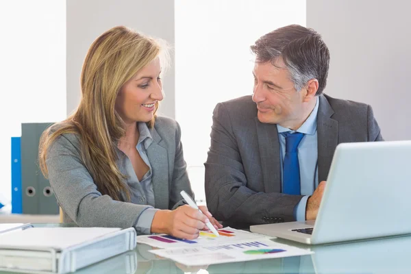 Dos personas de negocios felices sonriendo el uno al otro tratando de entender cifras —  Fotos de Stock