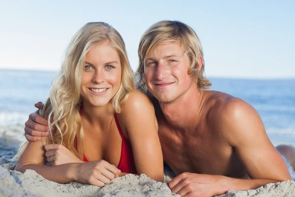 Lachende paar liggend op het strand — Stockfoto