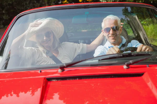 Cheerful mature couple in red cabriolet — Stock Photo, Image