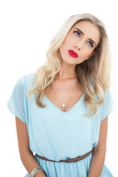 Koncentrerad blond modell i blå klänning tittar bort — Stockfoto