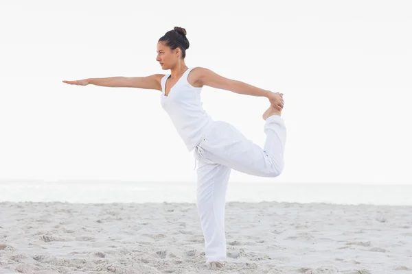 Brunette woman wearing all white stretching in yoga pose — Stock Photo, Image