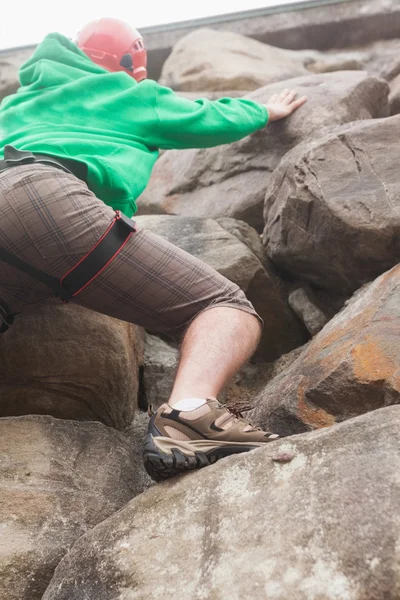 Entschlossener Mann besteigt eine große Felswand und sieht den Gipfel — Stockfoto