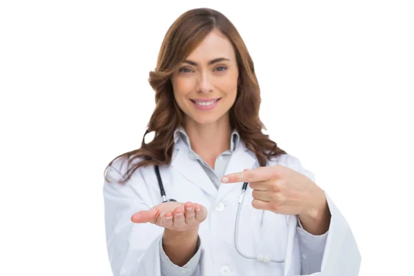 Médico sorridente apontando para algo em sua mão — Fotografia de Stock