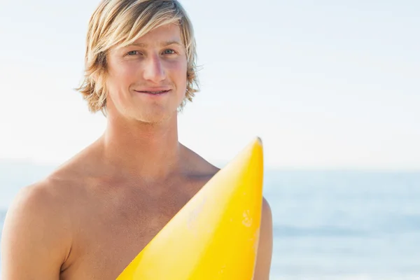 Bello uomo con la sua tavola da surf sorridente alla macchina fotografica — Foto Stock
