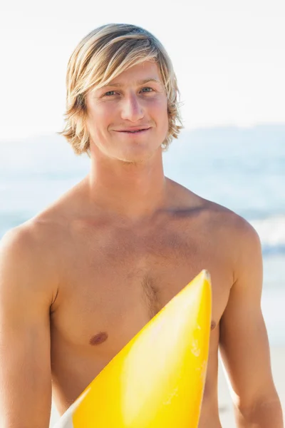 Hombre guapo con su tabla de surf en la playa — Foto de Stock