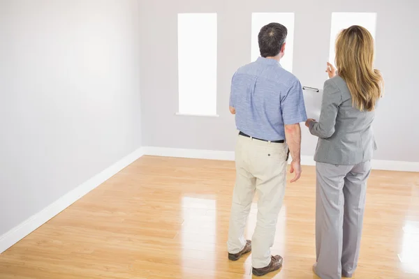 Blonder Makler zeigt einem potenziellen Käufer ein Zimmer — Stockfoto