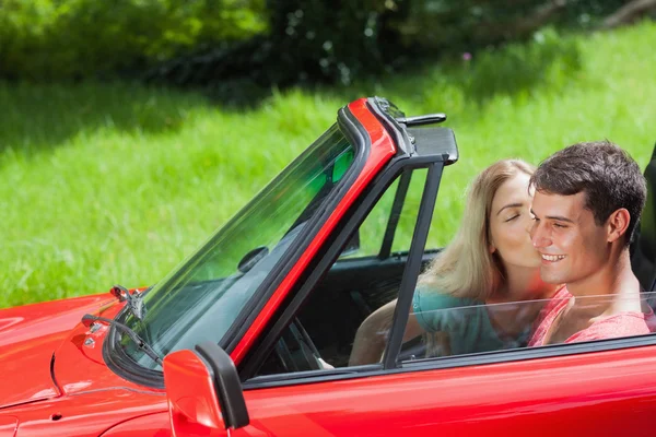 Hübsche Blondine küsst ihren Freund im roten Cabriolet — Stockfoto