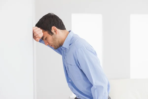 Triste hombre apoyando su cabeza contra una pared — Foto de Stock