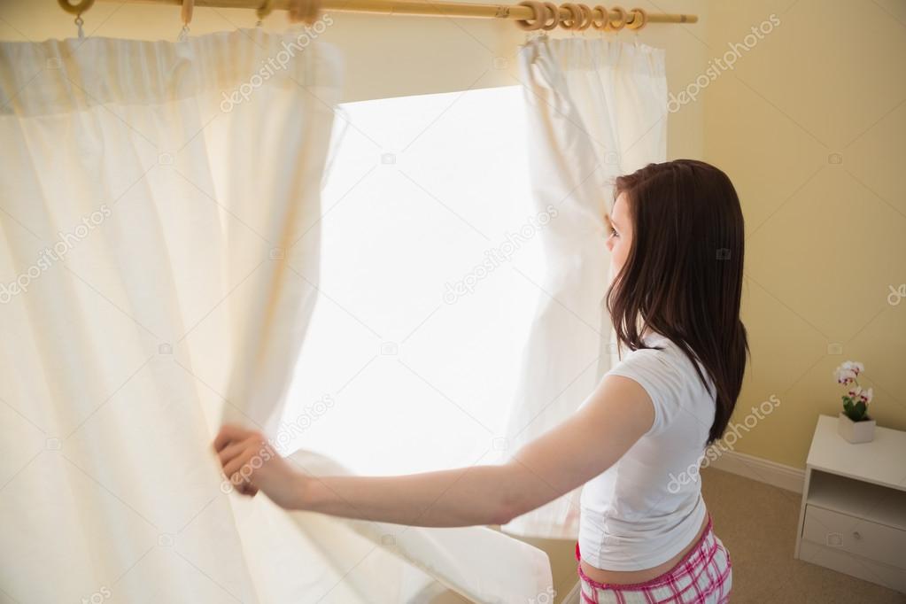 meisje openen gordijnen in een slaapkamer — Stockfoto ... meisje openen gordijnen in een slaapkamer — Stockfoto ...