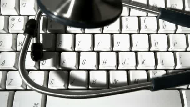 Stetoskop faller och studsar på datorns tangentbord — Stockvideo