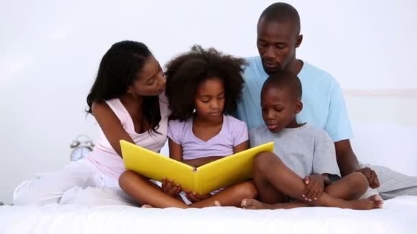 Familie liest Buch auf dem Bett — Stockvideo