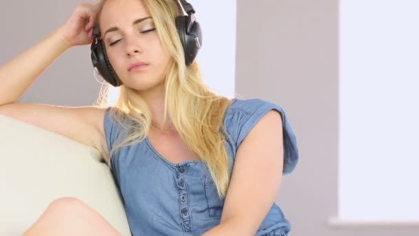 Krásné dospívající odpočinkem na jejím gauči a poslechu hudby — Stock video