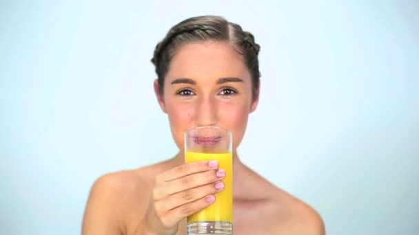 Happy young woman drinking orange juice — Stock Video