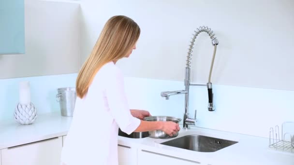 Blonde vrouw vullen water op pan — Stockvideo