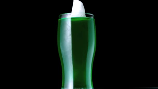 Foam falling into pint of green beer — Stock Video