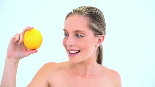 Cheerful woman holding an orange in her hand — Stock Video