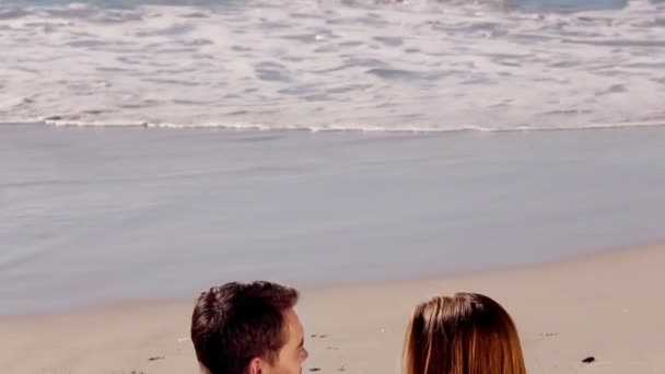 Couple relaxing on the sand while looking at the sea — Stock Video