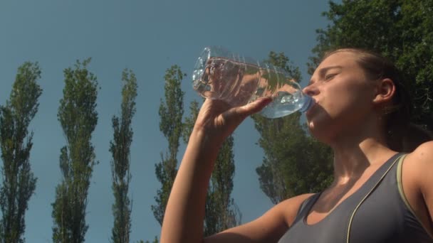 Athletic sporty woman drinking a bottle of water — Stock Video