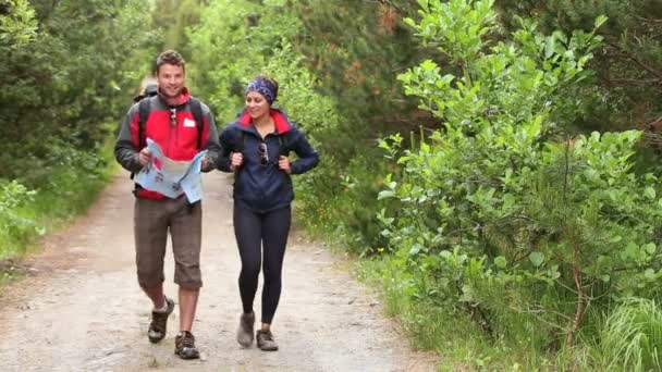 Para spacerująca szlakiem kraju, patrząc na mapę — Wideo stockowe