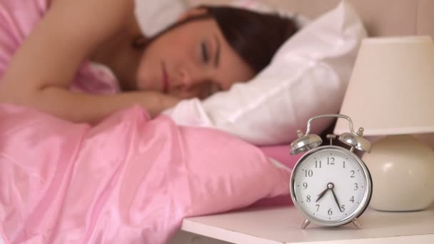 Reloj despertador sonando y despertando a una mujer dormida — Vídeos de Stock