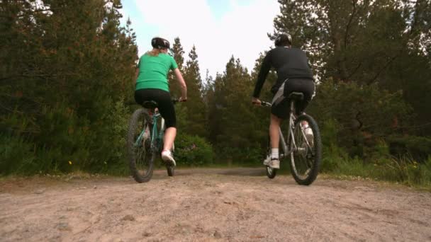 Passen paar mountainbiken in het platteland samen weg van de camera — Stockvideo
