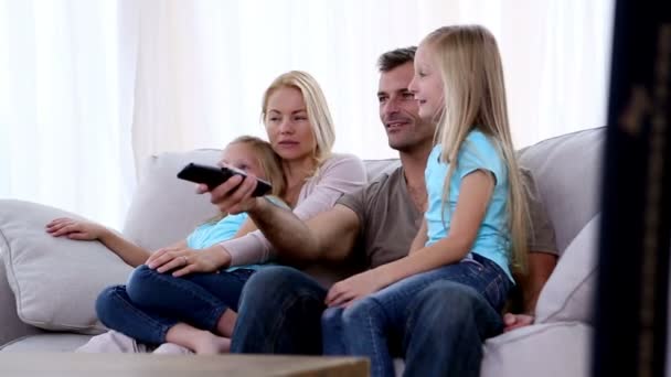 Familia viendo la televisión en el sofá — Vídeo de stock