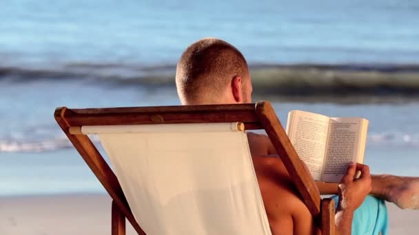 Man lezen op het strand — Stockvideo