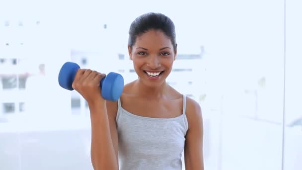 Beautiful woman holding dumbbells — Stock Video