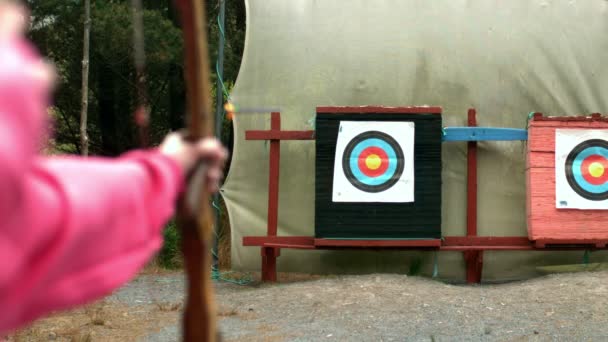 Woman shooting bow and arrow to the target — Stock Video