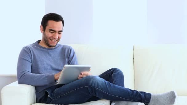 Homem usando um tablet no sofá — Vídeo de Stock