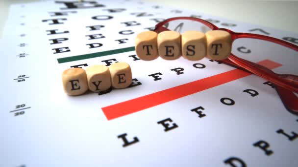 Eye test dice falling on eye test with reading glasses — Stock Video