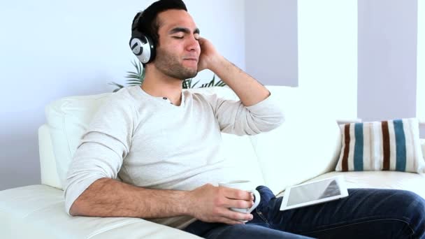 Человек слушает музыку со своим планшетным компьютером — стоковое видео