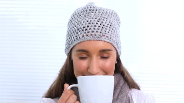 Giovane donna con cappello e sciarpa annusare la sua tazza — Video Stock