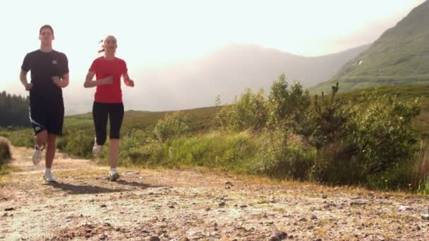 Ajuste pareja jogging en un país camino — Vídeos de Stock