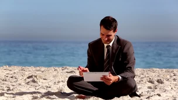 Uomo d'affari non stressato utilizzando tablet pc sulla spiaggia — Video Stock