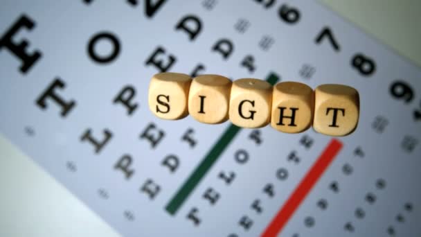 Dice spelling out sight falling on eye test — Stock Video